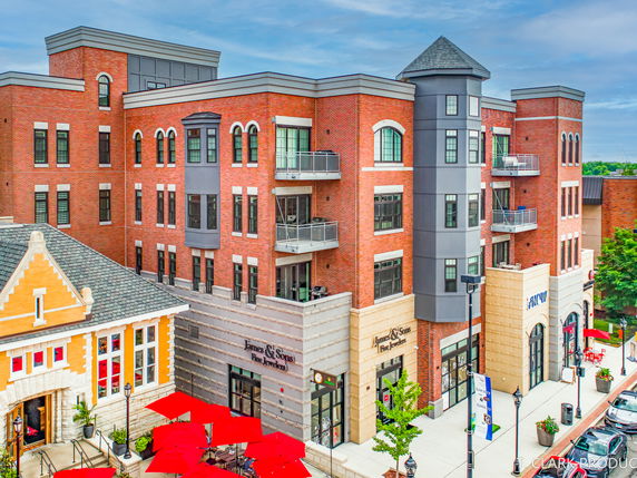 Front view of a multi-story brick commercial building with storefronts.