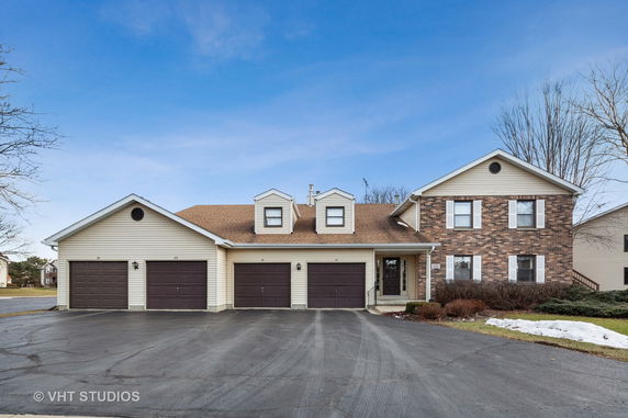 Front view of a house with multiple garages and a brick facade.