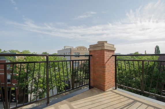 Balcony view overlooking buildings and trees.