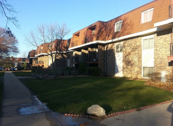 Front view of a multi-story building with brick facade and roof dormers.