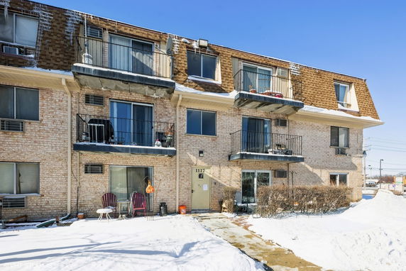 Front view of a three-story residential building with balconies.
