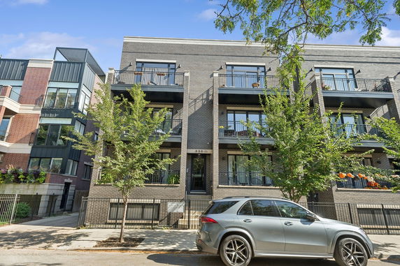 Front view of a modern multi-story apartment building with balconies.