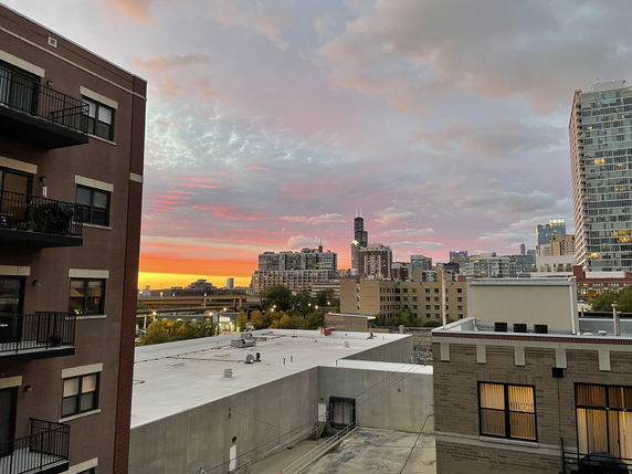 Panoramic view of city buildings at sunset.