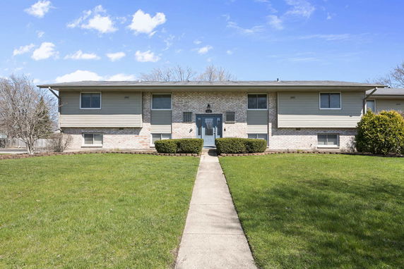 Front view of a two-story house with a brick and siding exterior.