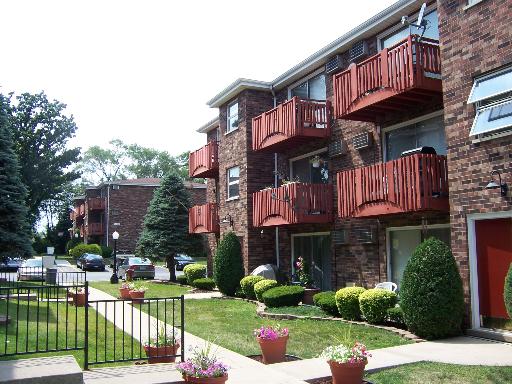Front view of a multi-story apartment building with balconies.
