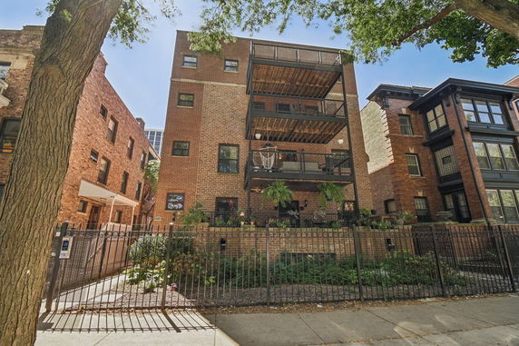 Front view of a multi-story brick building with balconies.