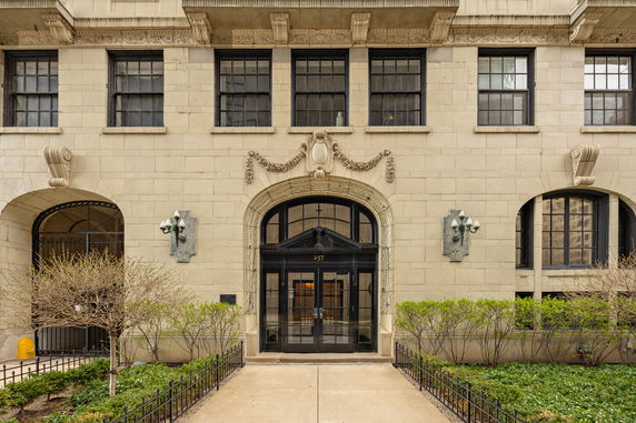 Front view of a building entrance with an arched doorway and decorative architectural details.