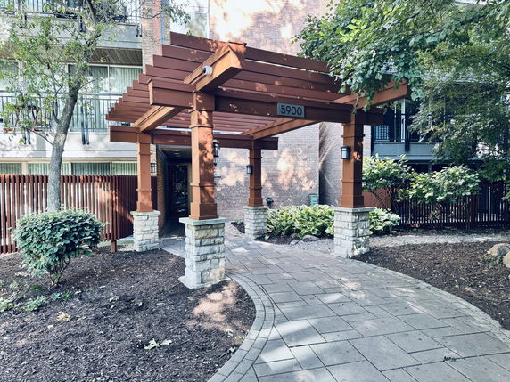Entrance of a building with a wooden pergola structure.