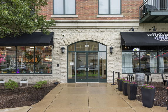 Front view of a commercial building with large glass windows and stone facade.