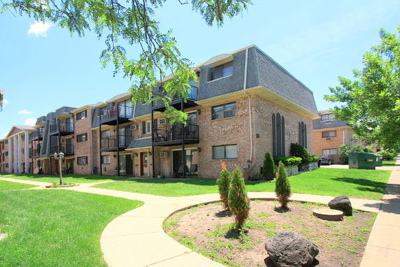Front view of a multi-story apartment building with balconies.