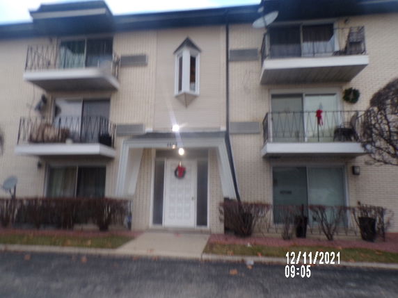 Front view of a three-story residential building with balconies.