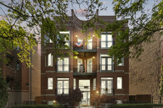 Front view of a multi-story brick building with balconies.