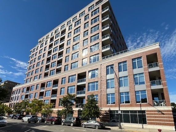 Front view of a multi-story brick building with numerous windows and balconies.