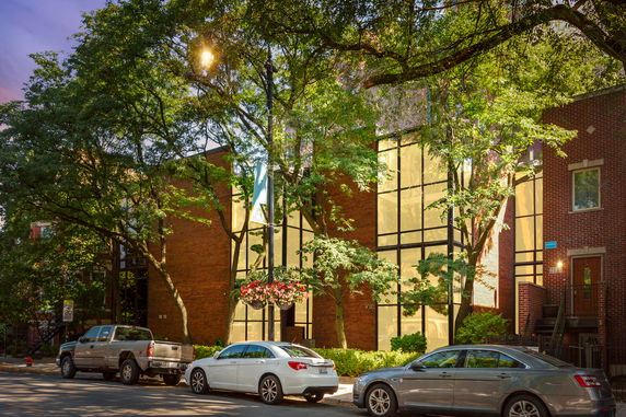 Front view of a brick building with large glass windows.