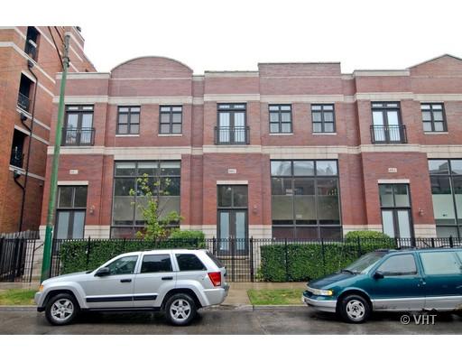 Front view of a multi-story brick building with large windows and multiple entrances.