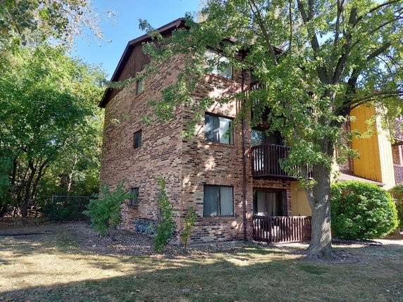 Side view of a three-story brick building with balconies.