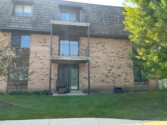 Front view of a multi-story brick building with balconies.