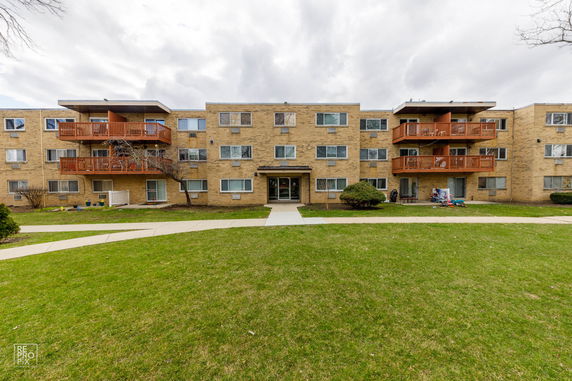 Front view of a three-story apartment building with balconies.