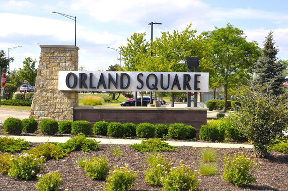 Front view of a stone entrance sign for a location named Orland Square.
