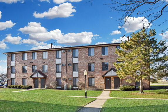 Front view of a three-story brick apartment building.