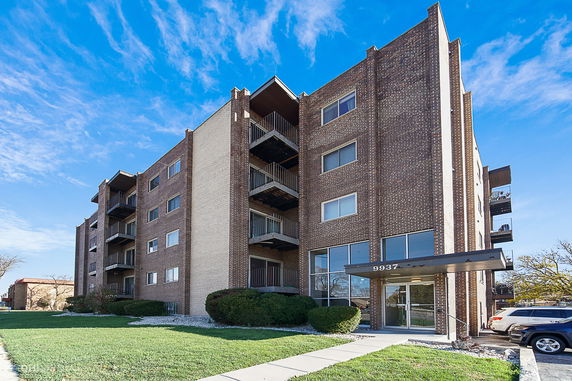 Front view of a multi-story brick building with balconies.