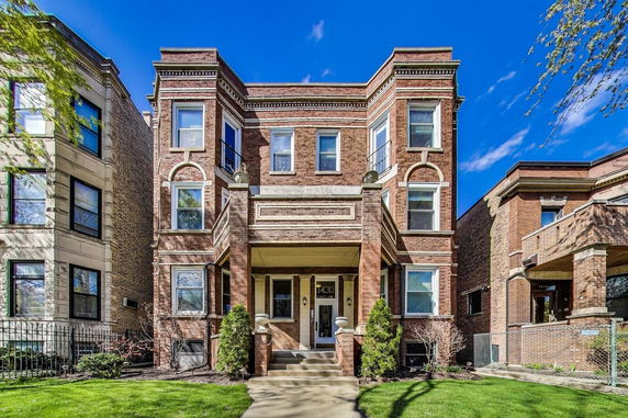 Front view of a multi-story brick building with decorative architectural features.