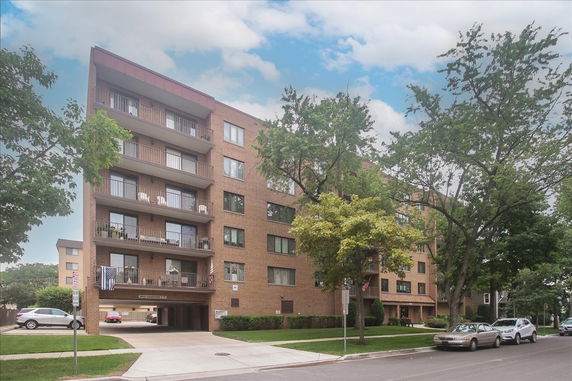 Front view of a multi-story apartment building with balconies.