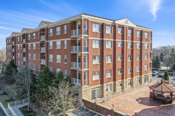 Front view of a multi-story brick building with balconies.