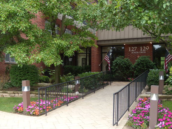Front view of a brick building with an entrance ramp and landscaping.