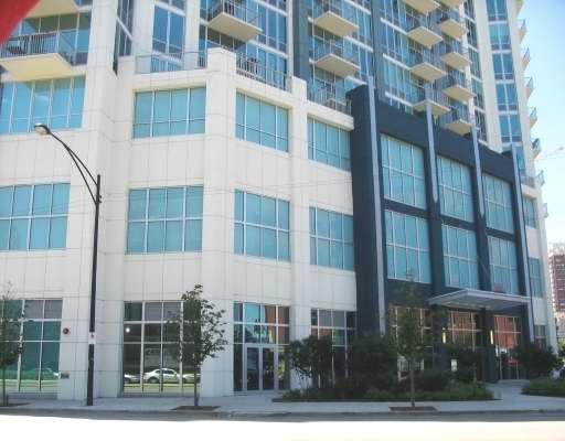 Front view of a multi-story building with large windows and balconies.