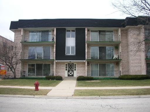Front view of a three-story residential building with balconies.