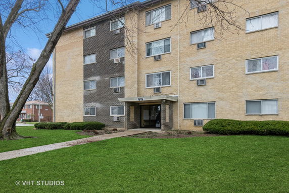 Front view of a multi-story apartment building with brick facade.