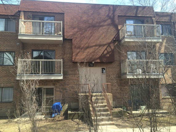 Front view of a multi-story apartment building with balconies.