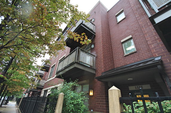 Front view of a brick apartment building with balconies.