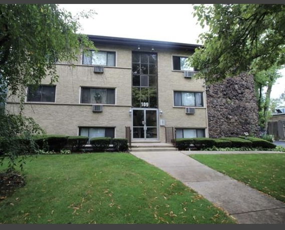 Front view of a three-story apartment building with a central entrance.