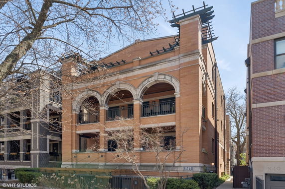Front view of a multi-story brick building with arched balconies.
