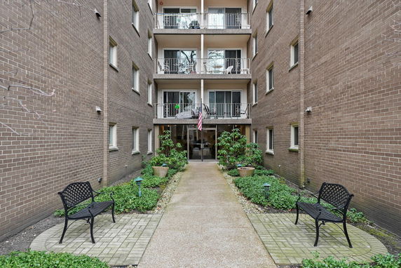 Front view of a multi-story brick building with balconies.