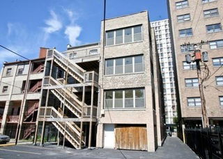 Exterior view of a multi-story building with fire escape stairs.