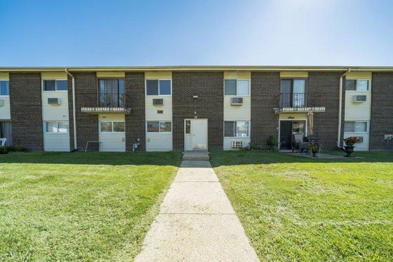 Front view of a two-story apartment building with brick exterior and multiple windows.