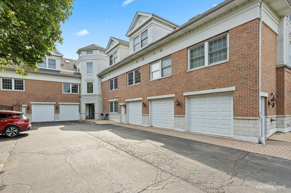 Front view of a multi-story brick building with multiple garage doors.