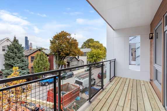 View from a building balcony overlooking a street and cityscape in the distance.