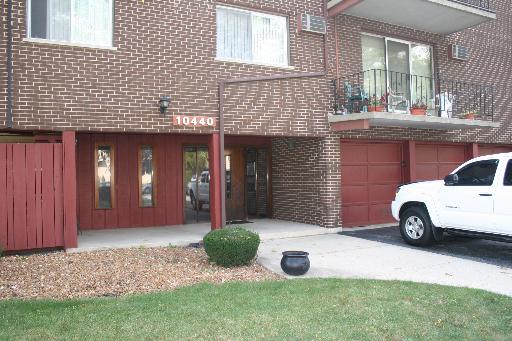 Front view of a brick house with balconies and a garage.