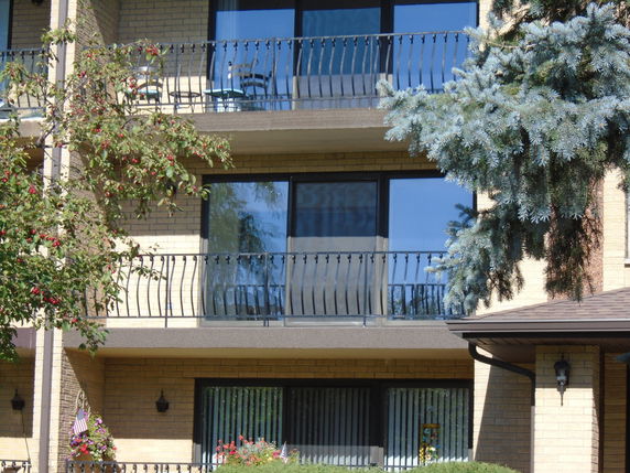 Front view of a multi-story building with balconies and large windows.