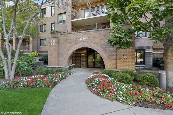Front view of a brick apartment building with archway entrance.
