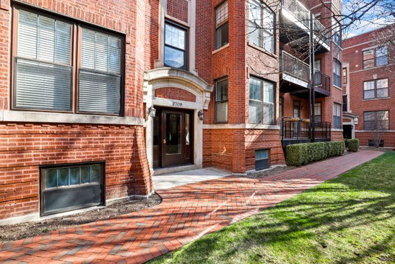 Front view of a brick apartment building with decorative entrance.