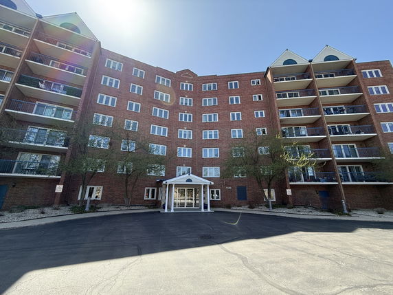 Front view of a multi-story brick building with balconies.