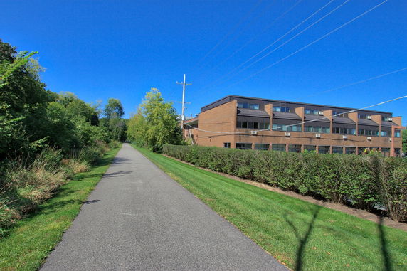 Front view of a brick multi-story building next to a pathway.