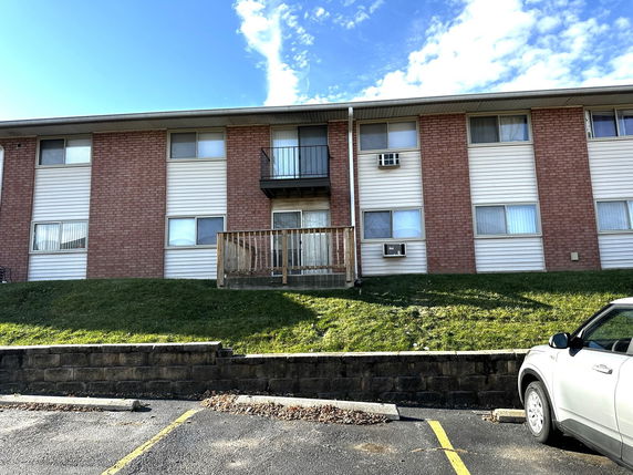Front view of a two-story residential building with brick and siding exterior.