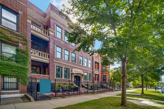 Front view of a multi-story brick building with balconies.