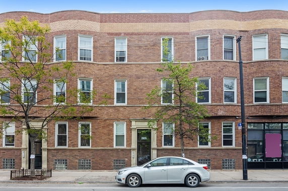 Front view of a brick apartment building with multiple floors.